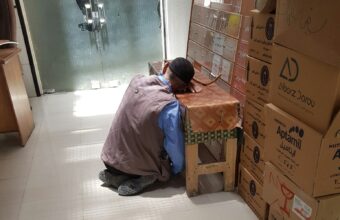 男性彎腰搬動紙箱，搬重物時的腰部負擔