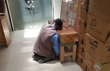 男性彎腰搬動紙箱，搬重物時的腰部負擔