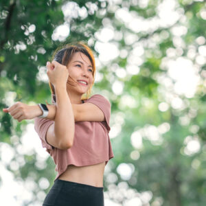 女性在戶外伸展手臂，舒緩運動後的上肢與肩膀痠痛