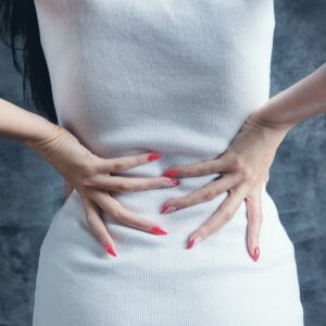 女性雙手扶著下背，腰痛與下背不適的情境