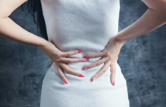 女性雙手扶著下背，腰痛與下背不適的情境