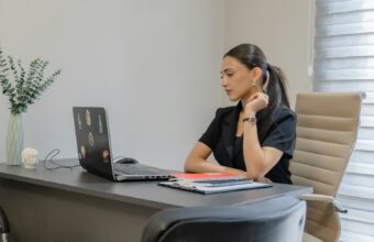 上班族女性坐在辦公桌前長時間工作，肩頸容易痠痛緊繃